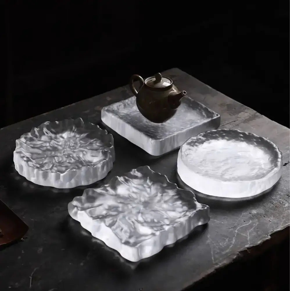 Silver-toned textured ceramic tea trays with organic leaf embossing used as crystal glass coaster and jewelry display panel