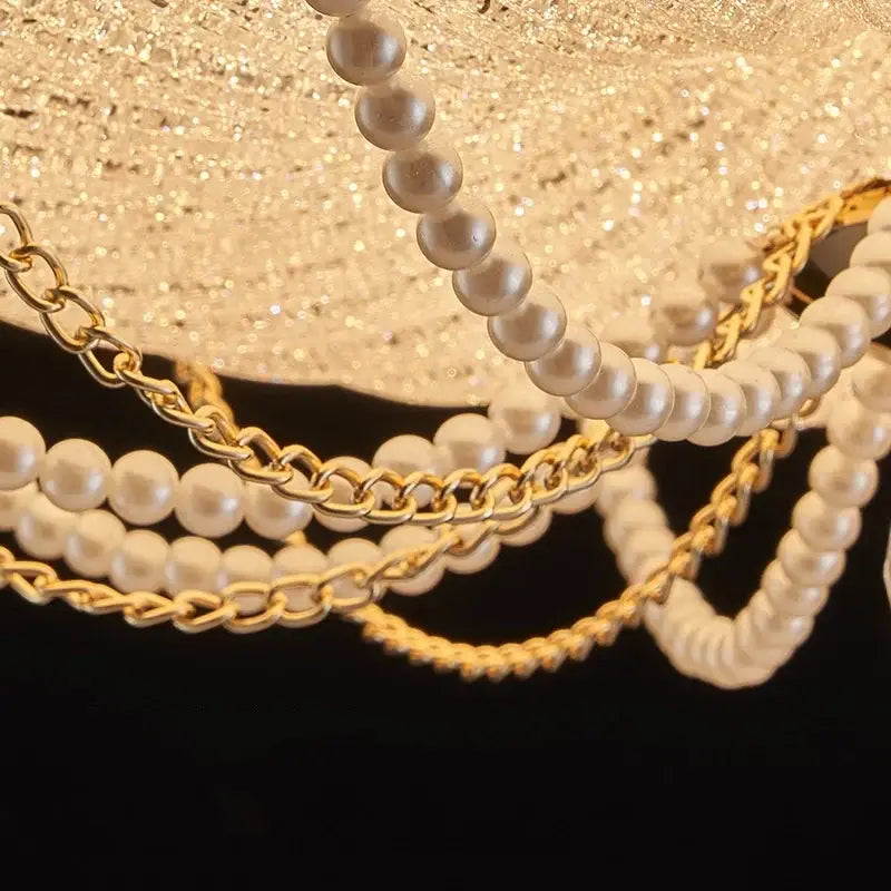 Elegant white pearl strands intertwined with gold chains complement a scalloped gold decorbites crystal dimmable led ceiling light