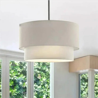 A modern scandinavian beige double linen fabric pendant light with off-white shade and black metal rod for dining room