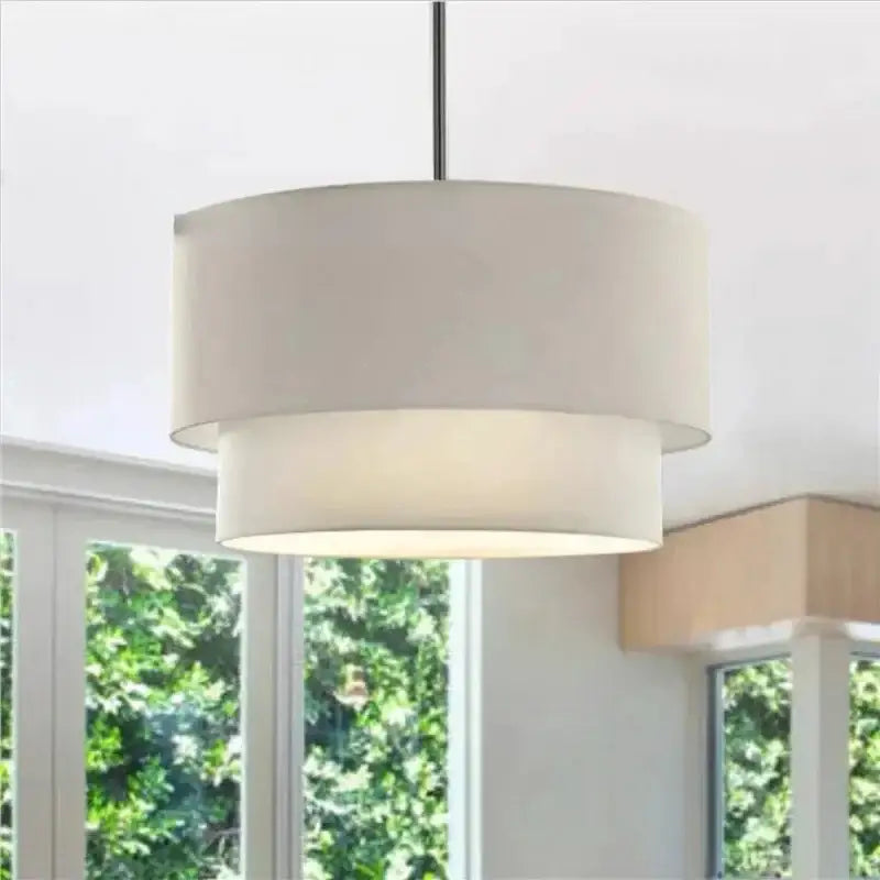 A modern scandinavian beige double linen fabric pendant light with off-white shade and black metal rod for dining room