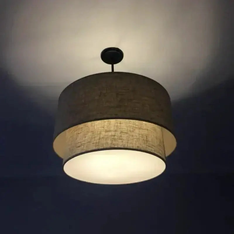 Scandinavian beige double linen fabric pendant light with warm-toned two-tiered linen fabric shade and dark metal fixture