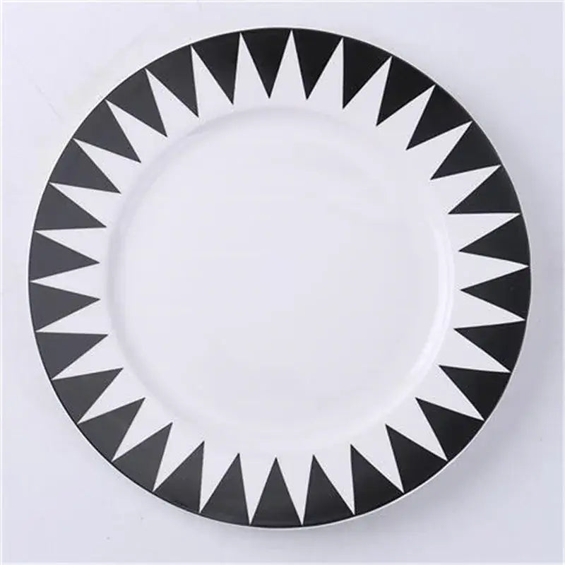 A white ceramic dessert plate with bold black triangular geometric pattern perfect for Scandinavian dining