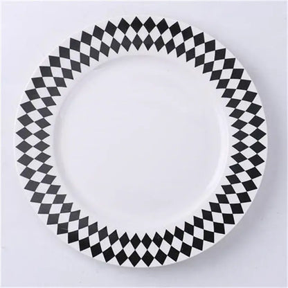 A white ceramic dessert plate with a bold black and white diamond pattern rim for decorbites ceramic dessert plates