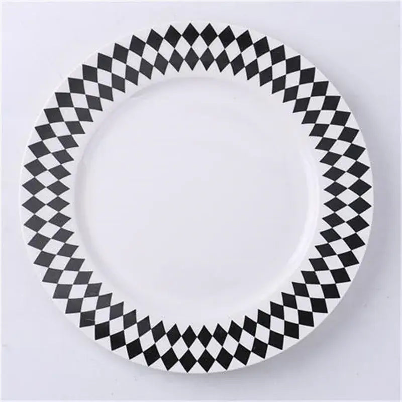 A white ceramic dessert plate with a bold black and white diamond pattern rim for decorbites ceramic dessert plates