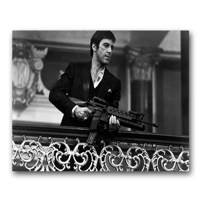 Black-and-white tony montana canvas wall art print of man in pinstripe suit holding assault rifle by ornate railings