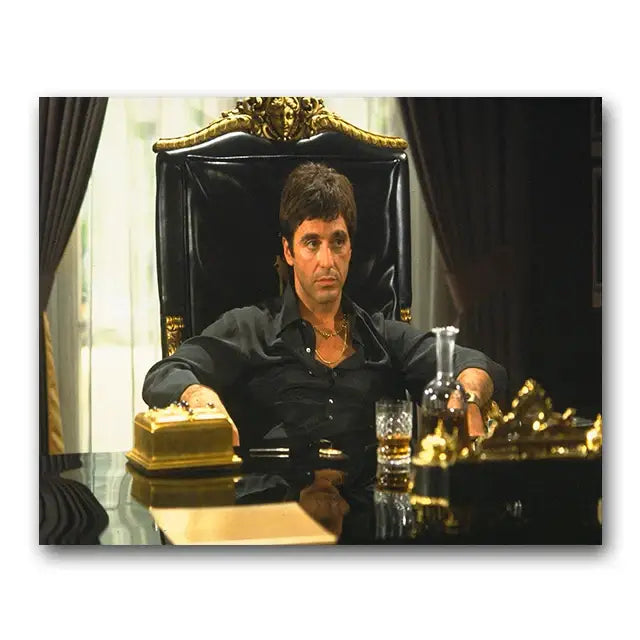 Black leather office chair with ornate gold accents placed next to tony montana canvas wall art by decorbites