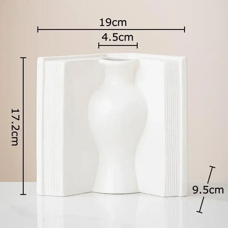 A sleek white ceramic vase shaped like an open book with ribbed spine details for creative flowers desk decoration