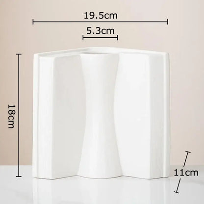 White ceramic vase with sculptural design and three flowing sections for creative flowers desk decoration by decorbites