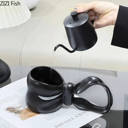 Black ceramic coffee mug with sculpted bowknot handle paired with decorbites bowknot ceramic teapot for tea serving