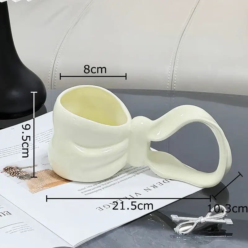 Cream-colored decorbites bowknot ceramic coffee mug with a smooth glossy finish for kitchen tea use