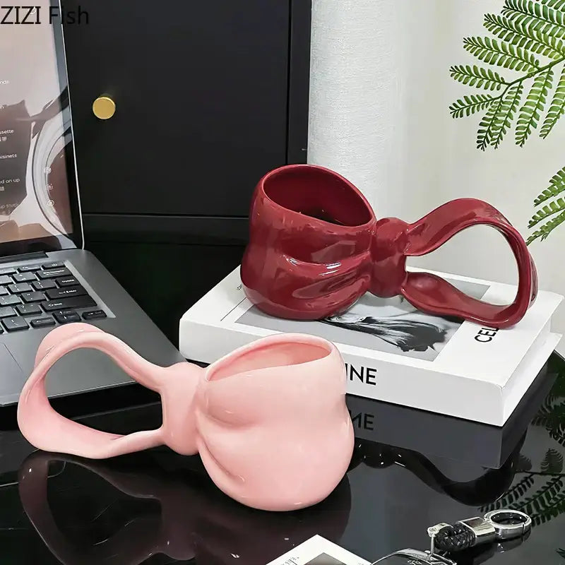 Glossy pink and red decorbites bowknot ceramic coffee mug with sculpted bow handle and reflective finish for kitchen use