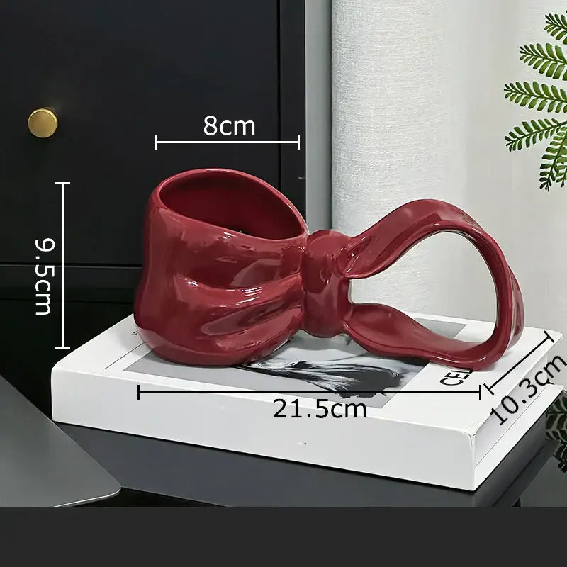 Glossy red decorbites bowknot ceramic coffee mug with a sculpted bow shape and smooth curved design for kitchen use
