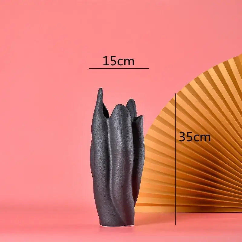 Black texture ceramic vase with sculpted leaf-like ridges and matte finish for living room decor by decorbites