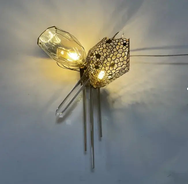 A sculptural gold glass shades pendant light featuring a clear bulb and intricate wire mesh for dining room use