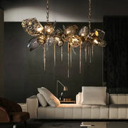 Sculptural gold-toned pendant light with glass shades and metallic drips for dining room chandelier lighting