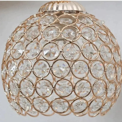 Sculptural gold violinist crystal wall lamp featuring a spherical gold-toned crystal wall sconce with interlocking rings
