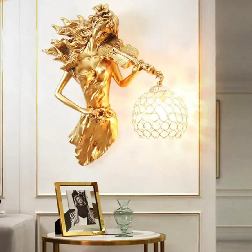 Gold sculptural wall lamp featuring a flowing violinist figure with an ornate crystal globe crystal wall lamp for living rooms