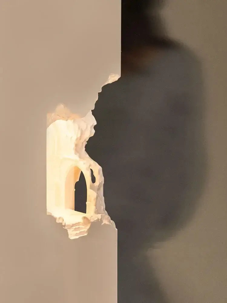 Sculptural off-white plaster wall sconces with arched openings featuring embedded night light for corridor use