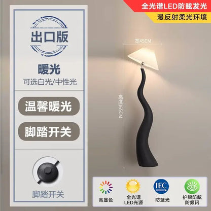 Black sculptural floor lamp with curved base and white triangular shade for decorbites cream resin floor lighting