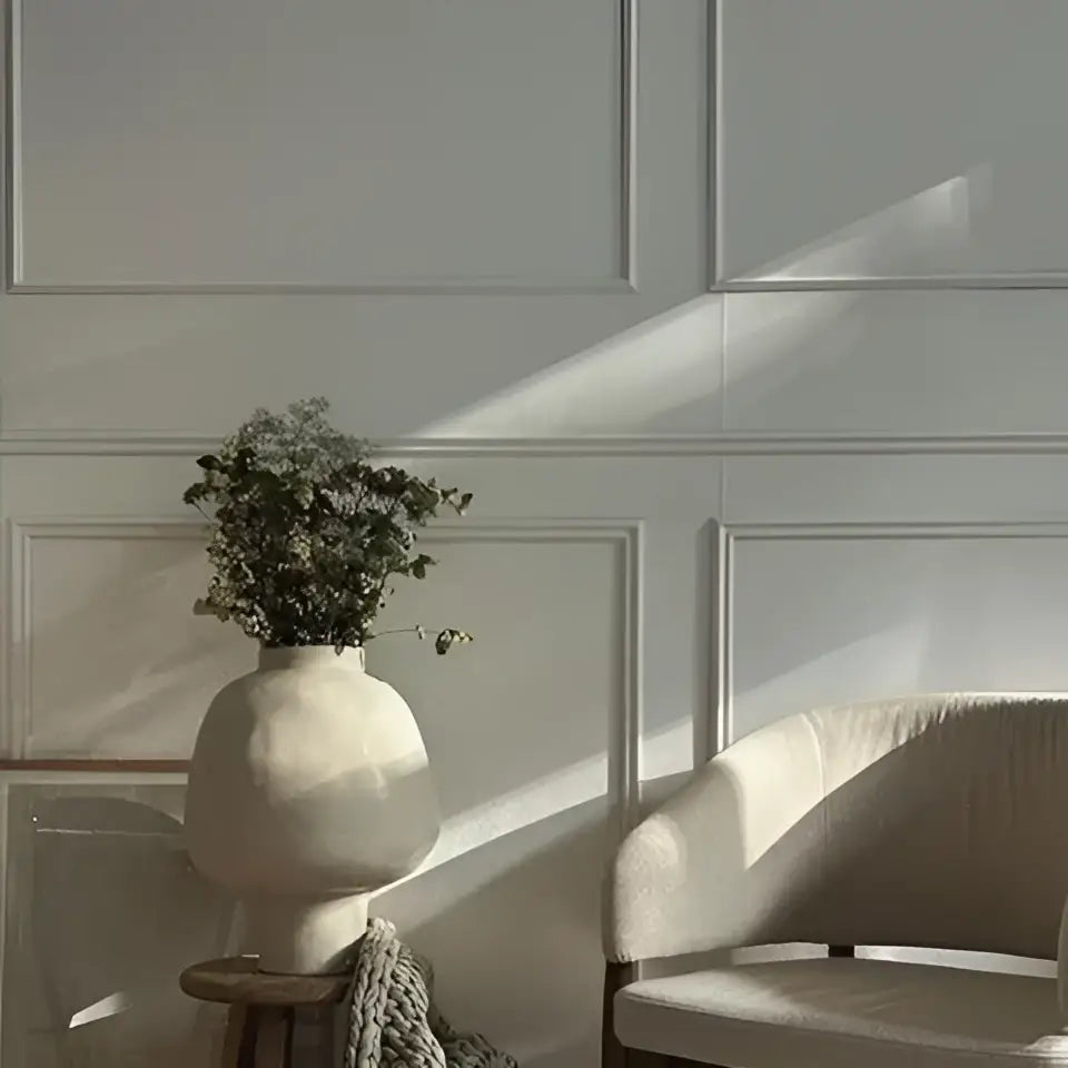 Matte white ceramic vase with hammer pattern and rounded body holding dried greenery for living room desk use