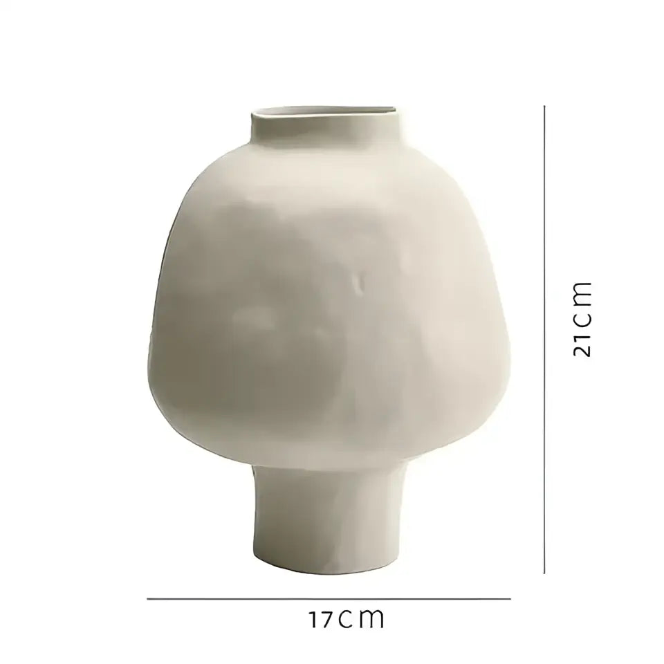 Matte white ceramic vase with rounded body and short stem base featuring a sculptural hammer pattern for living room desk