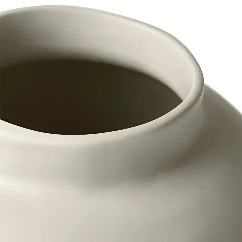 Cream-colored sculptural ceramic vase with a smooth rim and subtle hammer pattern for living room desk