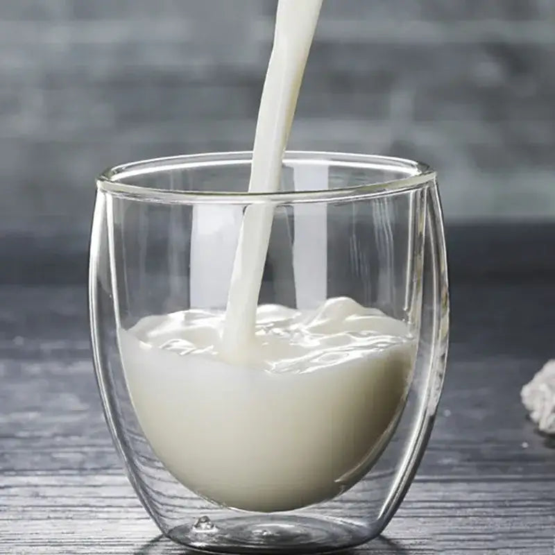 Set of 3 clear double wall glass cup tumblers featuring a glass cup filled with creamy white milk for kitchen and dining
