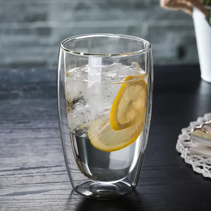 Set of 3 clear double wall glass cup tumblers filled with ice and lemon slices for kitchen and dining use