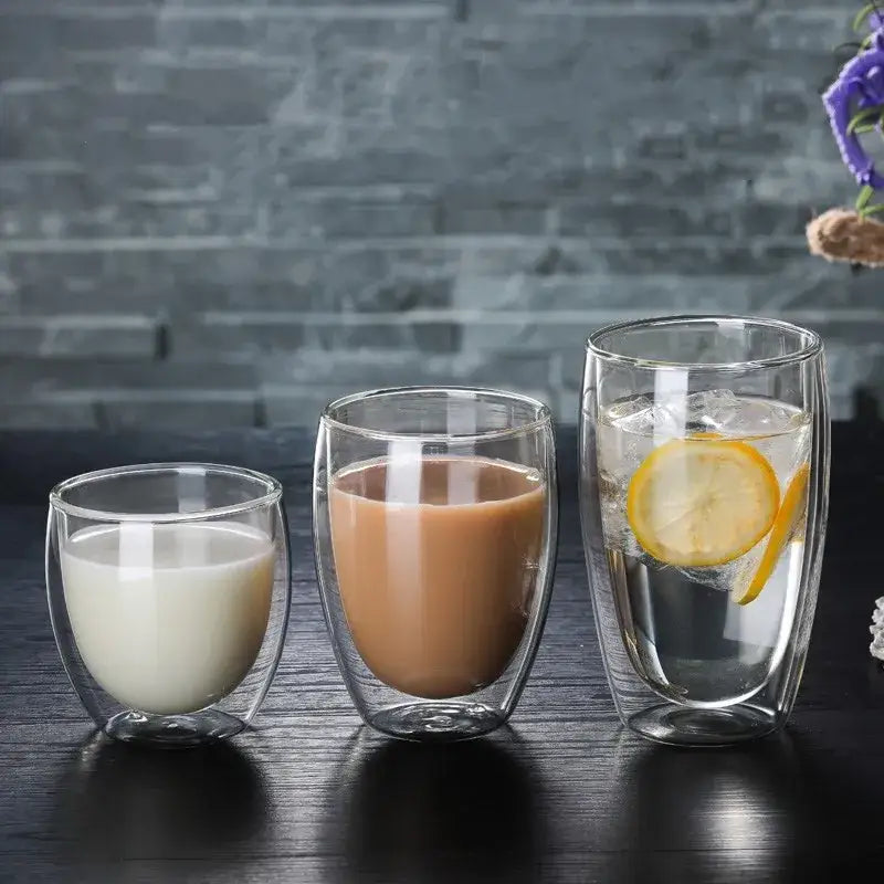 Set of 3 clear double wall glass cup tumblers filled with different beverages for kitchen and dining use
