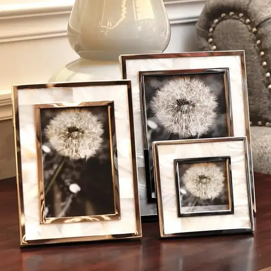 Set of three golden alloy shell photo frames with mother-of-pearl inlays displaying black-and-white dandelion photos