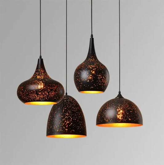 Set of 4 black and gold etched iron pendant light fixtures with speckled accents and warm yellow interiors for dining room