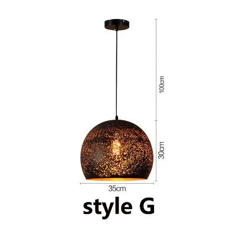 Set of 4 black and gold etched iron pendant light fixture with spherical dark textured pendant light and warm amber glow