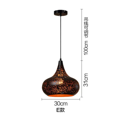 Set of 4 black and gold etched iron pendant light fixtures with dark brown speckled glass shade and orange glow
