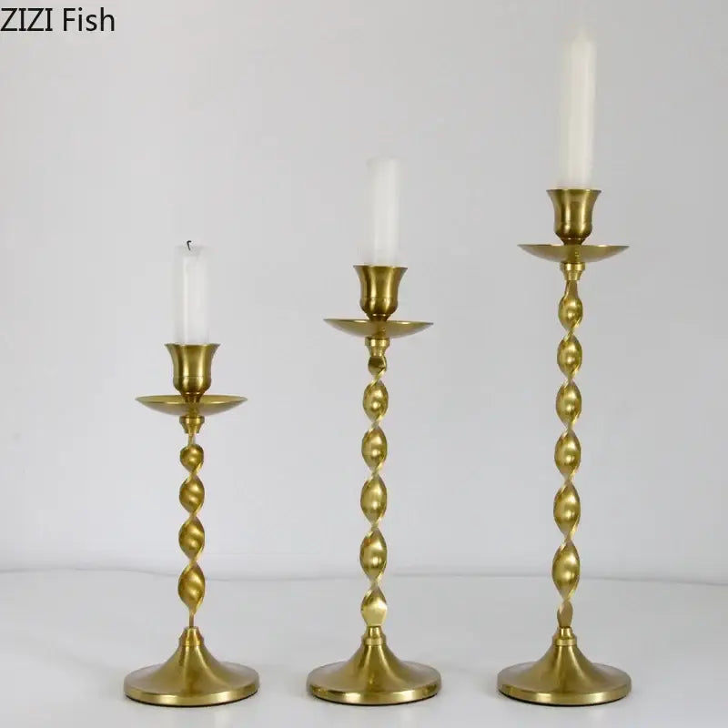 Set of three golden candlestick holders with twisted brass stems and white taper candles for dining room decorbites decor