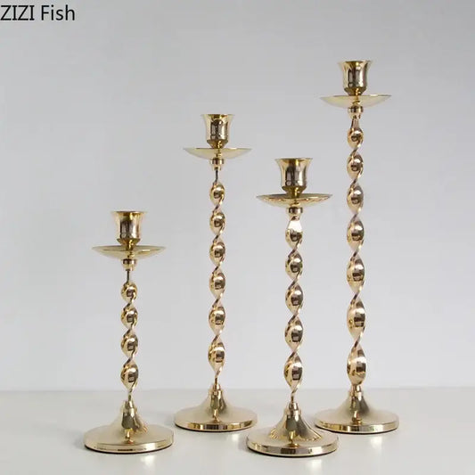 Set of 4 golden candlestick holders with twisted metal design and fluted bases for elegant dining room decorbites decor
