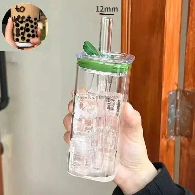 Clear rectangular glass water bottle with ice compartment green lid and straw alongside colored handle layer glass mugs set