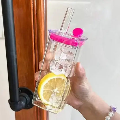 Set of 5 clear glass tumblers with vibrant pink colored handle layer lid and straw filled with ice and lemon slice