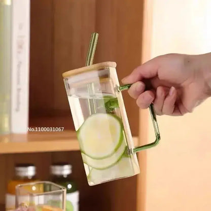 Set of 5 square glass mugs with colored handle layer featuring a clear glass mug with green handle and bamboo lid filled with cucumber water