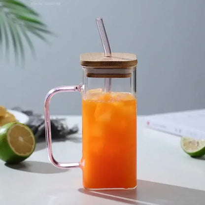 Clear glass mug with pink colored handle layer and bamboo lid filled with orange iced drink from set of 5 colored handle kitchen cups