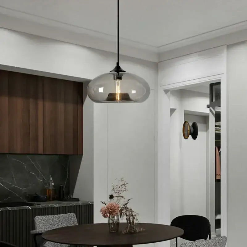 A sleek modern pendant light with translucent gray glass and exposed filament bulb from decorbites colorful glass pendant set