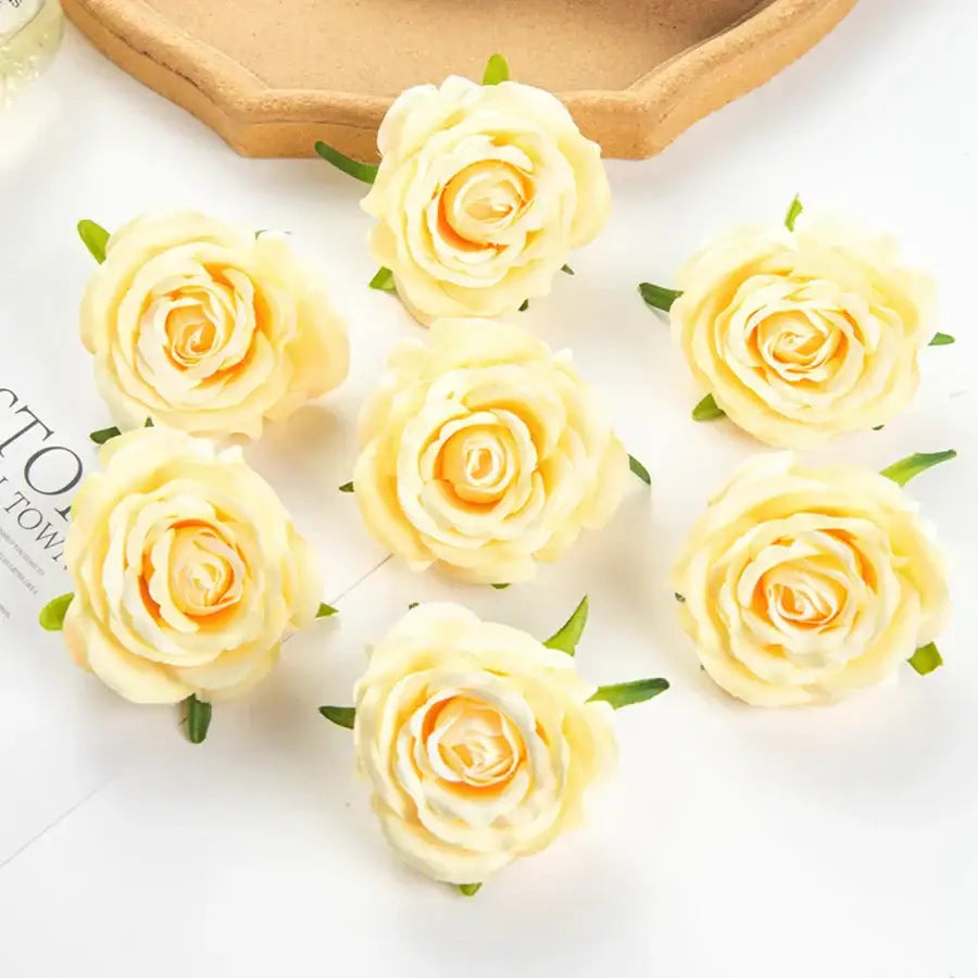 Delicate cream-colored artificial flowers with yellow centers and green stems complement silk blue rose wedding decor