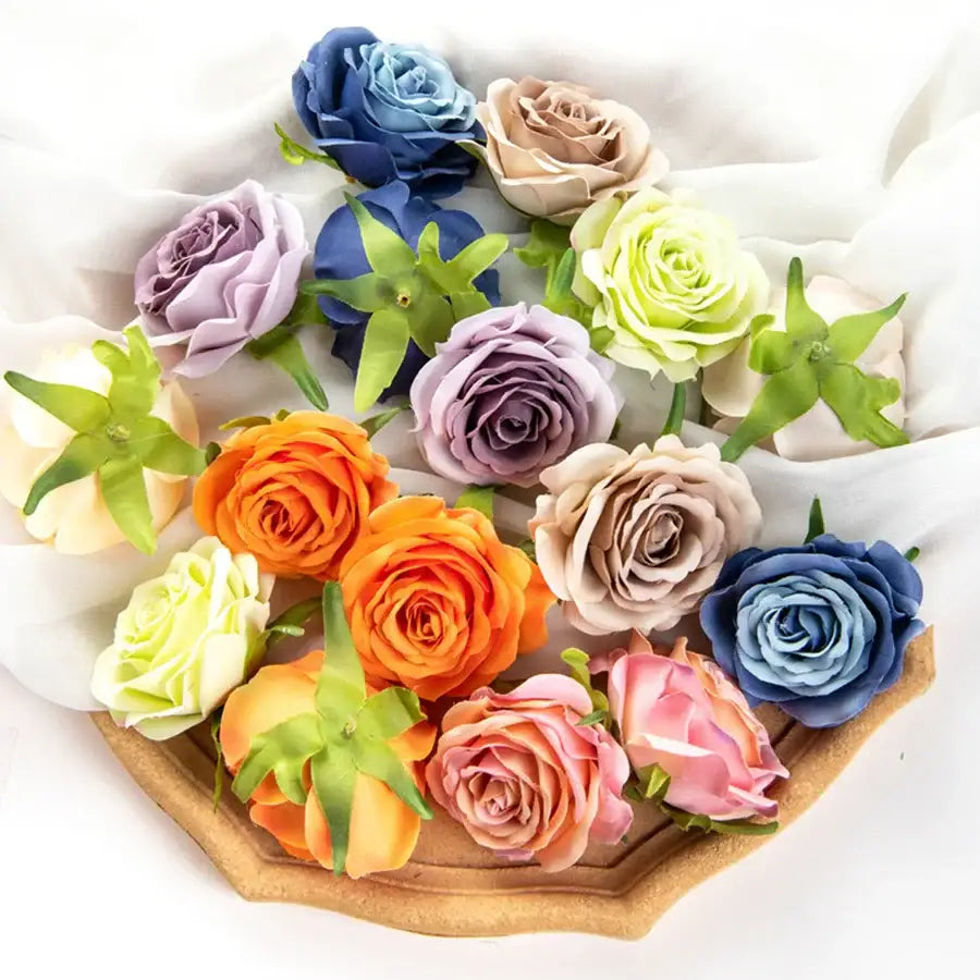 A collection of silk blue artificial flowers and colorful roses arranged on a wooden tray for wedding decor