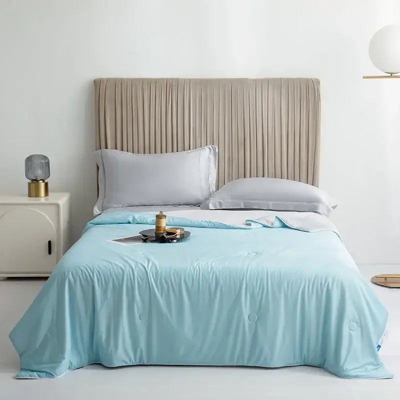 Light blue silky cooling queen quilt with subtle circular stitching for summer bedroom comfort