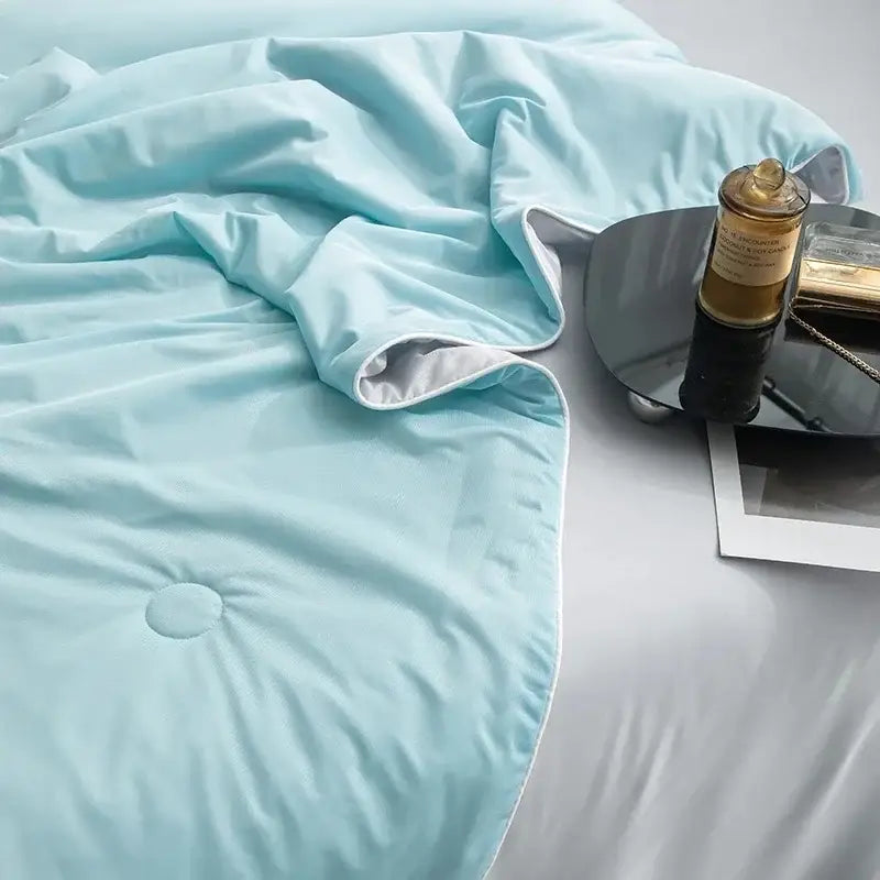 Soft light blue quilted cooling queen quilt with subtle sheen and white piping ideal for summer comfort