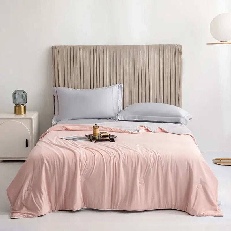 Soft blush pink quilted comforter with subtle button detailing for silky light blue cooling queen quilt bedroom summer use