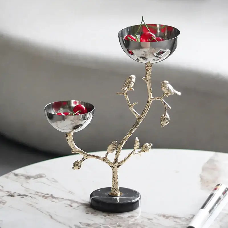 Silver and gold bird metal snack bowl fruit stand with silver-toned tree design and two compartments holding red cherries