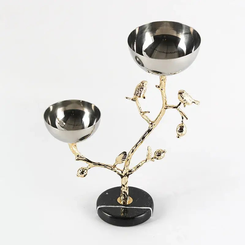 Gold-toned metal snack bowl stand with two stainless steel bowls and bird figurines on black marble base for dining room