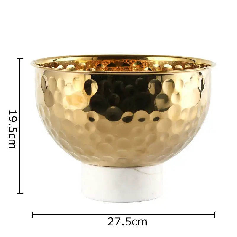 Gold-toned hammered metal fruits bowl with white marble base featuring hammer pattern for dining room pedestal tray