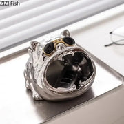 Silver bulldog ceramic ashtray with gold-rimmed black sunglasses and glossy metallic finish for living room desktop use