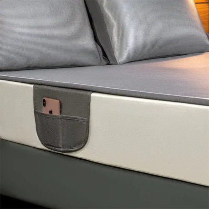 Gray fabric pocket attached to silver carbon light cooling mat bed frame holding a rose gold smartphone for decorbites carbon light